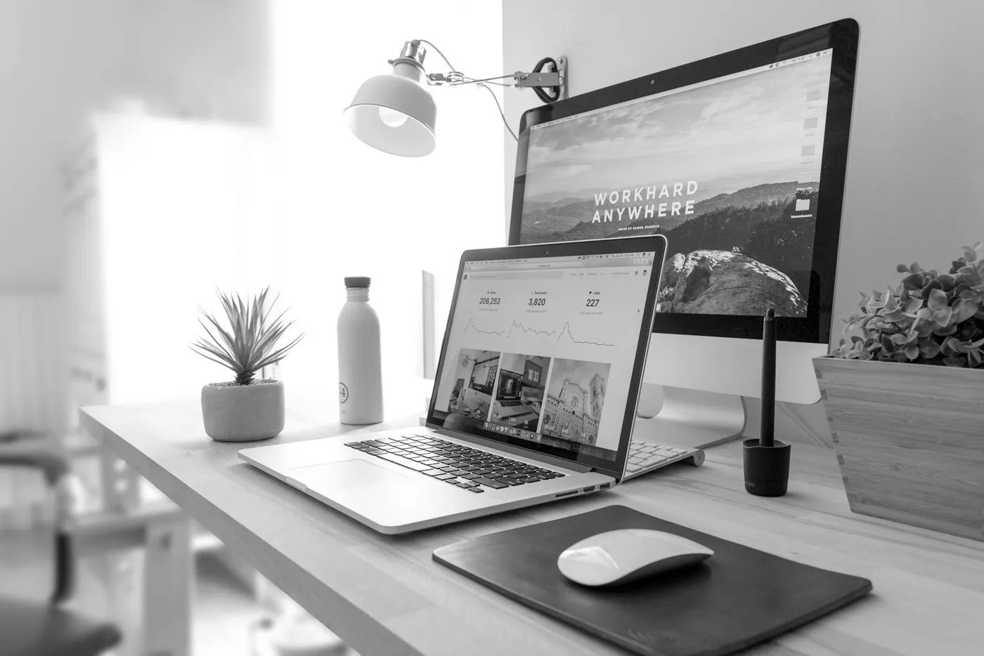 A laptop and desktop monitor side by side displaying website dashboards